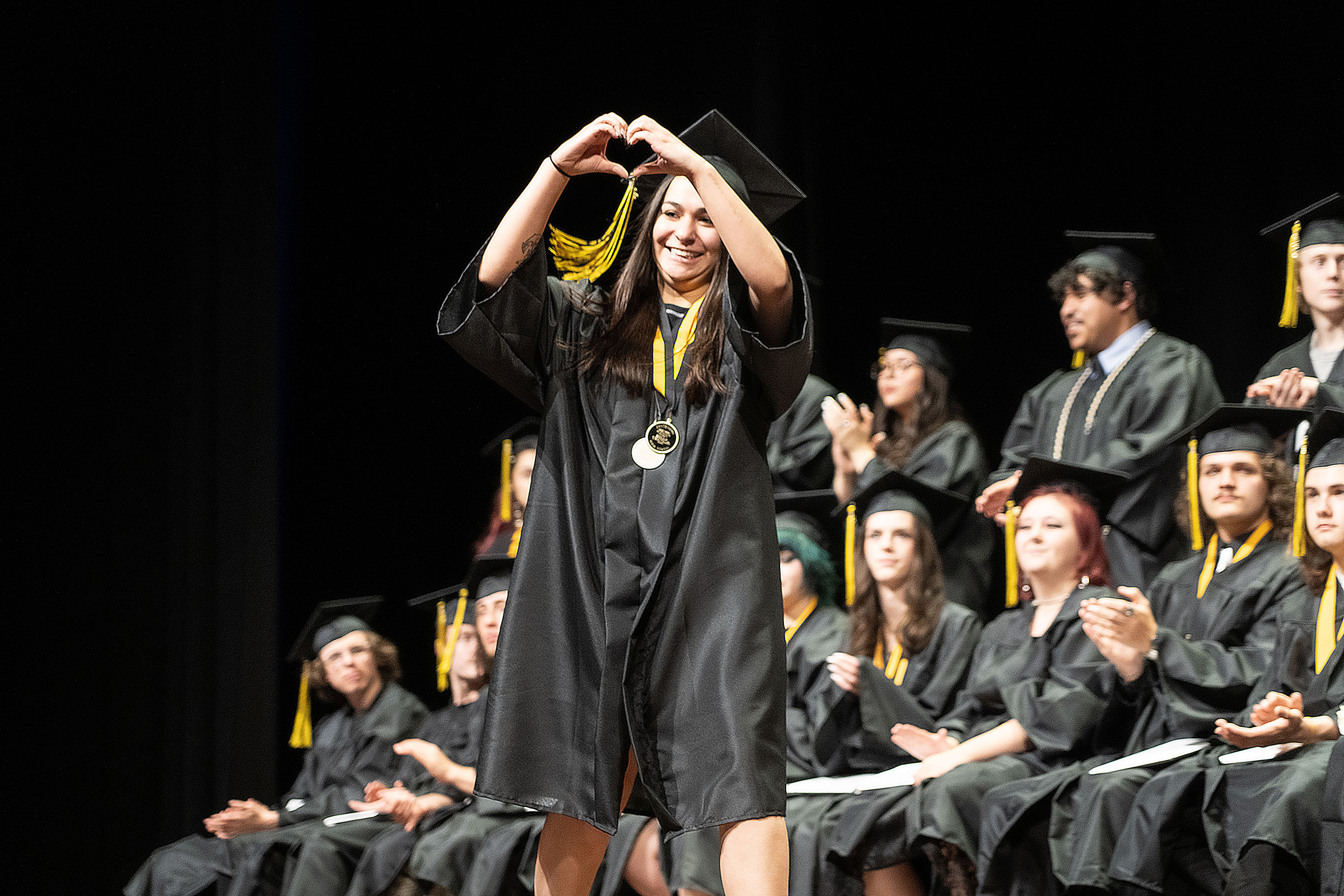 Centennial High School grad makes a heart with hands. 