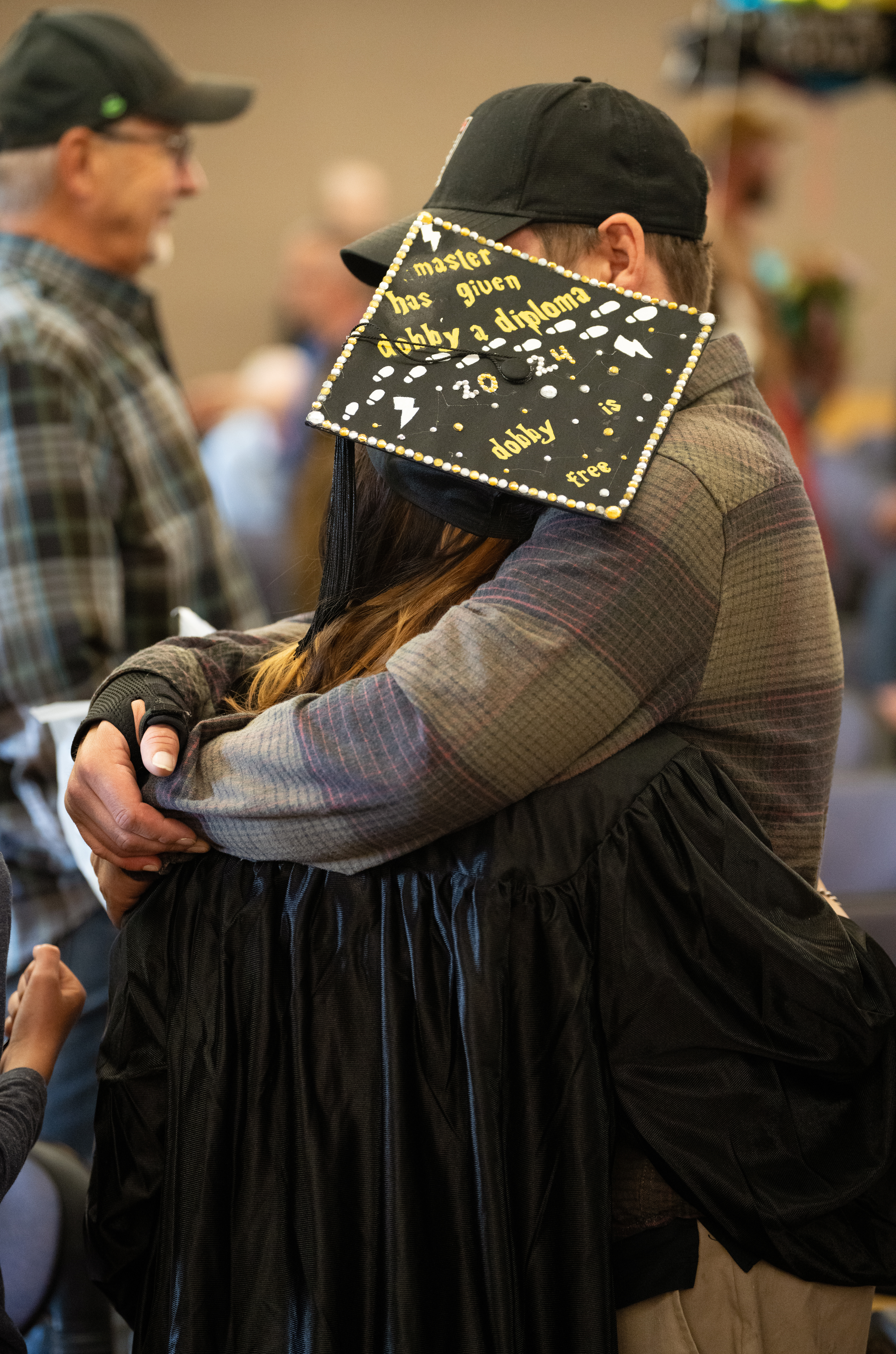 An OU graduate celebrates with a hug.