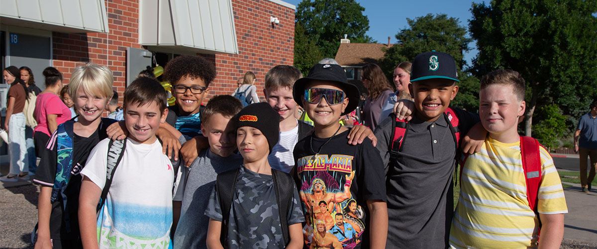 A group of elementary students smile at the camera. 