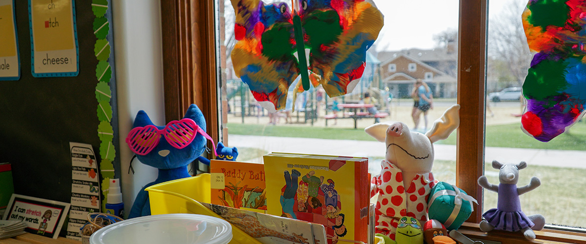 An elementary school classroom with tissue paper art on the window. 