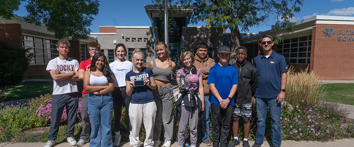 CTC students with a drone in front of a school.