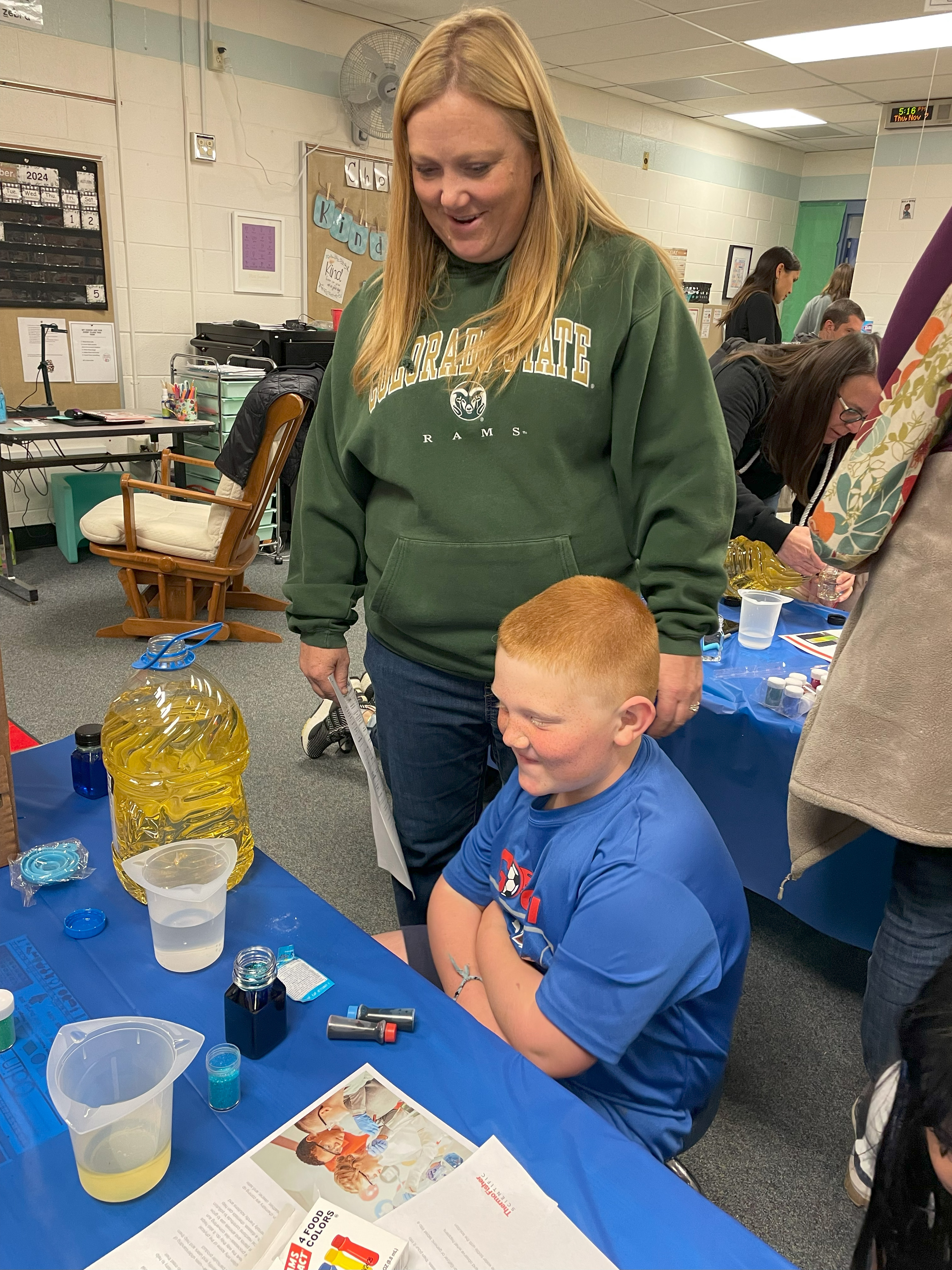 A student and parent look at the experiment on the table to see what happens.