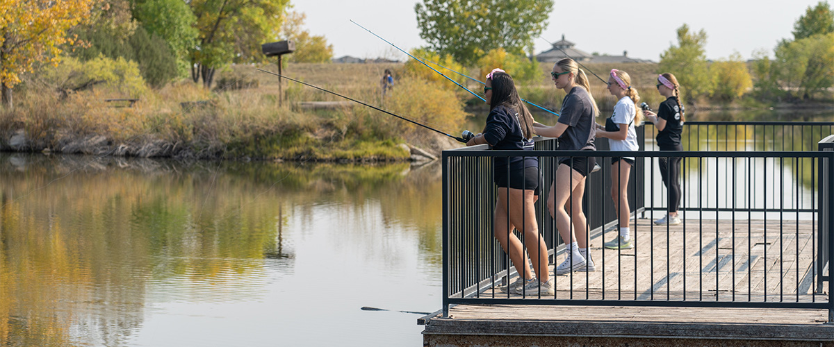 High school students fish off a dock. 