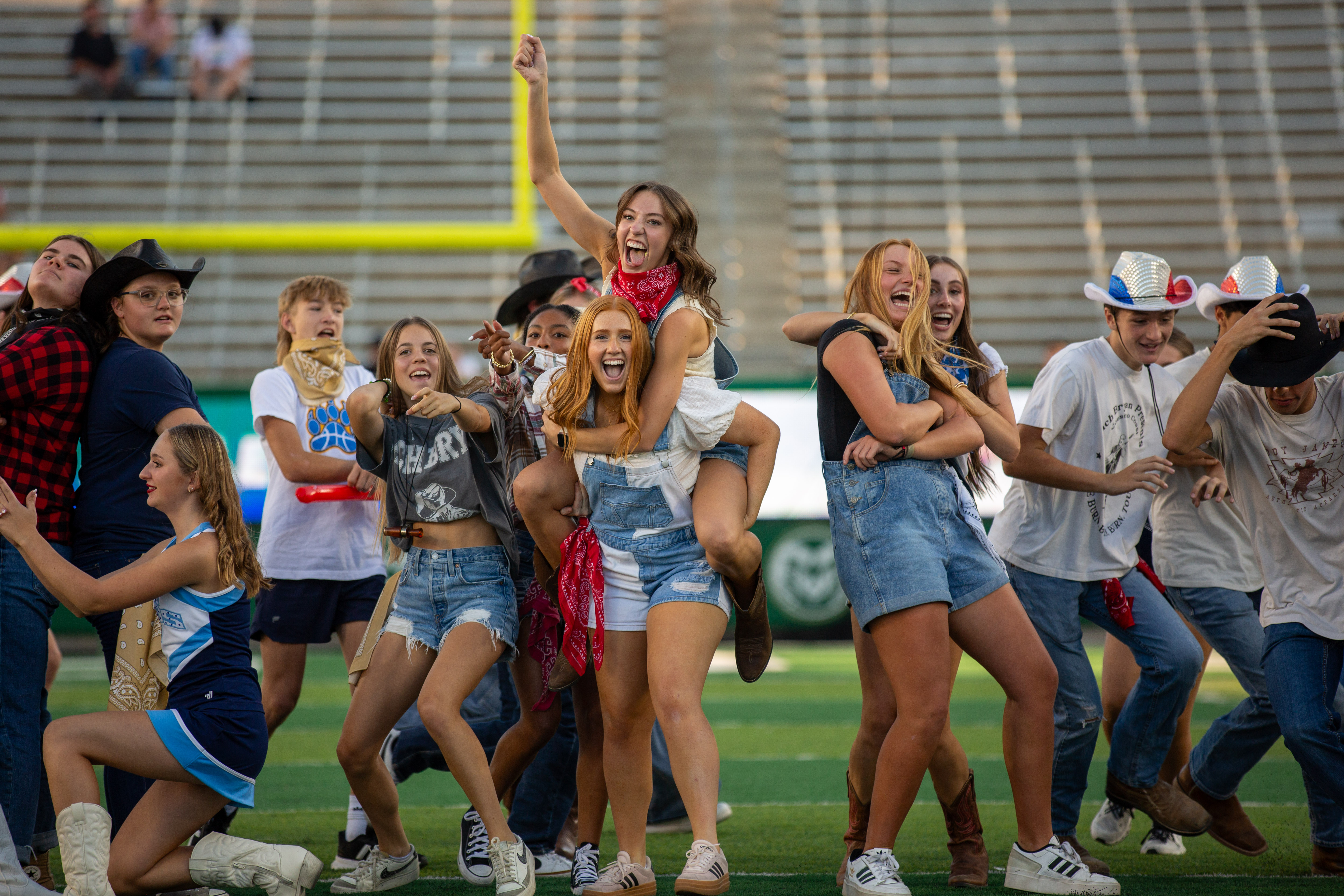 High school students perform on the field in cowboy boots