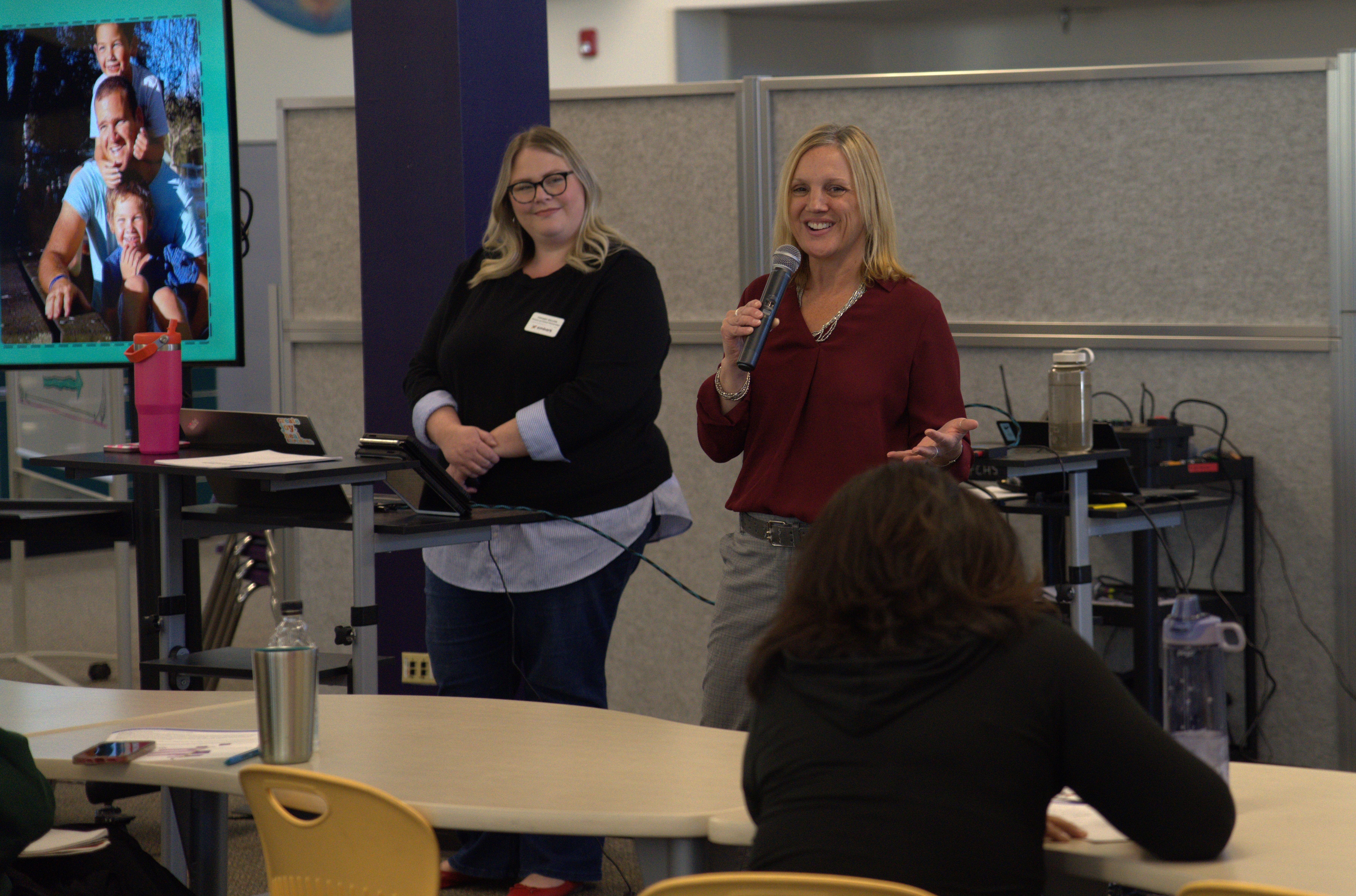 Two presenters talk to caregivers at the mental health summit. 