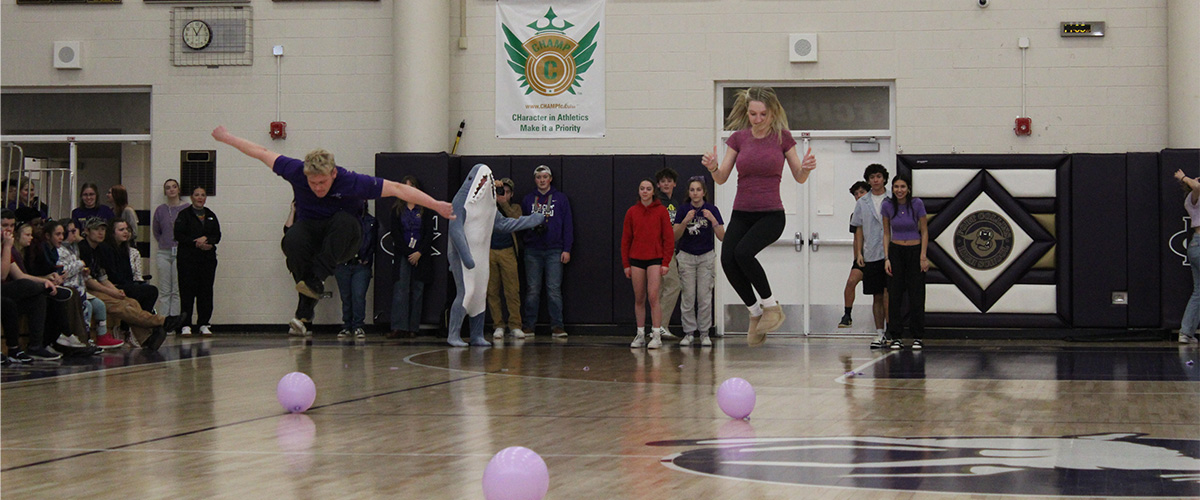 Two FCHS students race to pop balloons during a school assembly. 