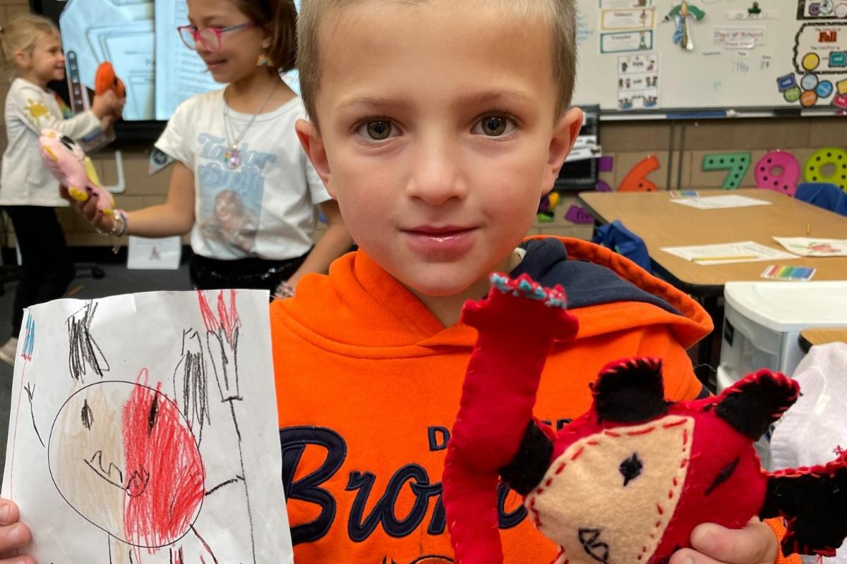 A student at McGraw Elementary shows the monstor he drew.  