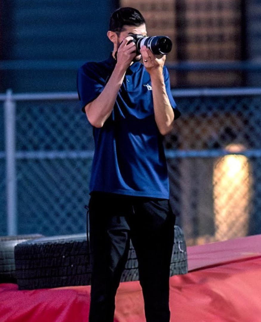 DJ James, PSD Athletics, holding a camera.