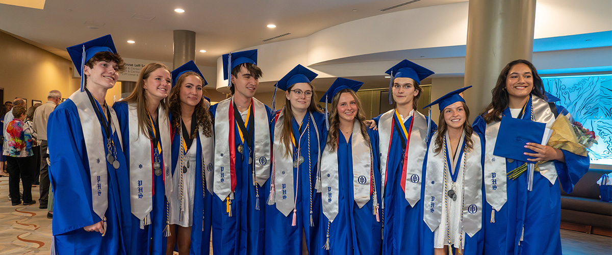 Poudre High School IB graduates smile at the camera after IB convocation.