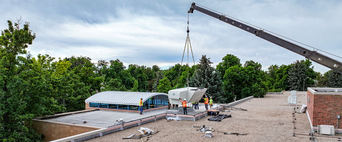 An air conditioning unit being lowered on to the roof of Dunn Elementary.