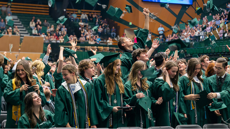 New PSD graduates throw caps in the air.