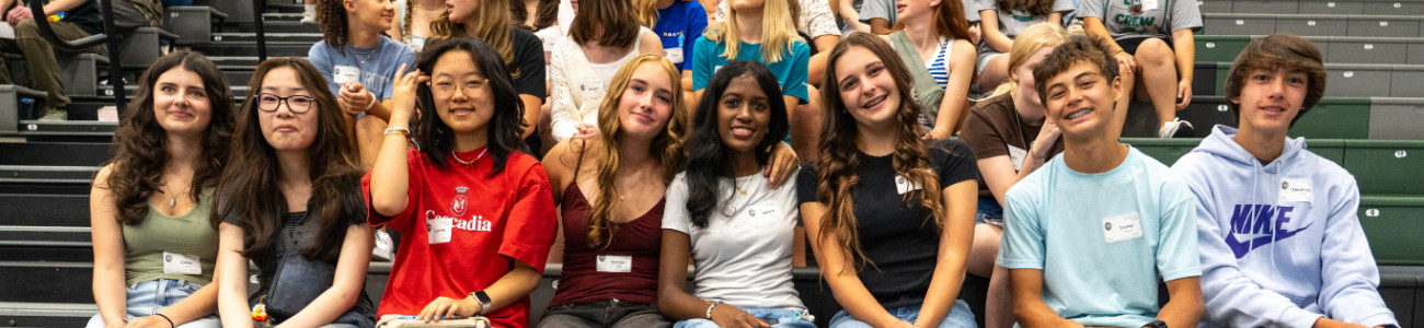 Diverse high school students smiling at a rally at school