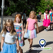 Students walking in a line with an attendance counts check mark.