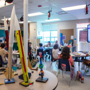 Classroom with rockets and students at desks. 