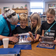 Students look at a photo album at the Dunn anniversary celebration. 