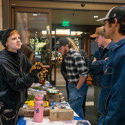 A student shows her project to others at the exhibition.